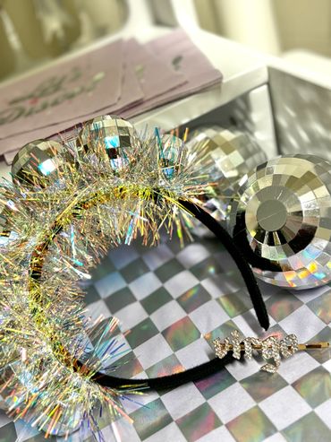 Sparkly Virgo hair clip and headband with disco ball decorations on a checkered surface.