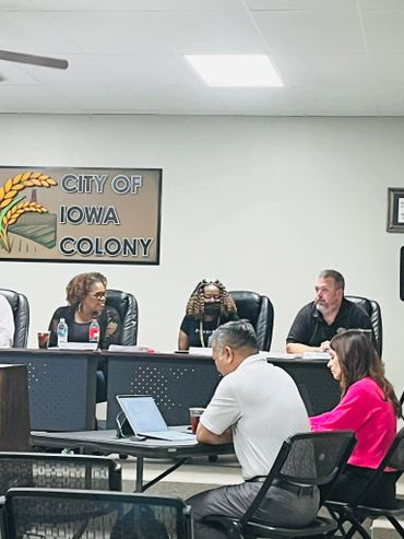 City of Iowa Colony meeting with officials at a conference table.