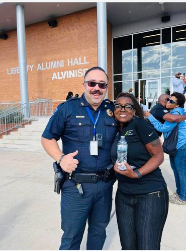 Police officer and woman smiling outside Liberty Alumni Hall.