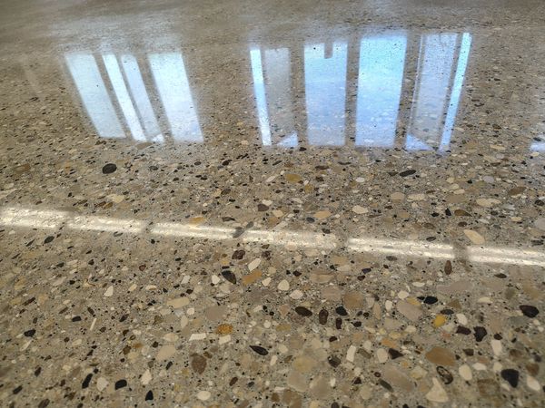 Polished terrazzo floor with window reflection.