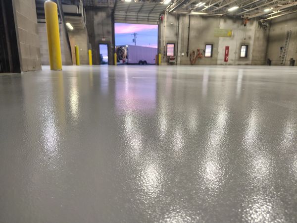 Shiny smooth industrial floor reflecting lights and sunset.