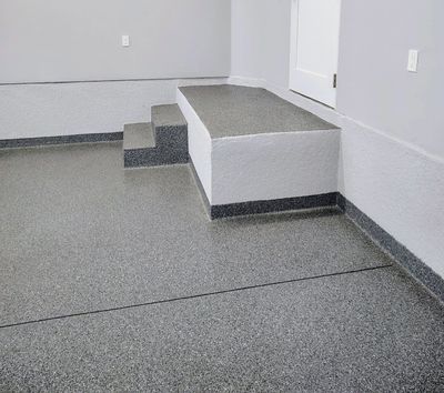 Concrete steps and platform with gray textured flooring and walls.