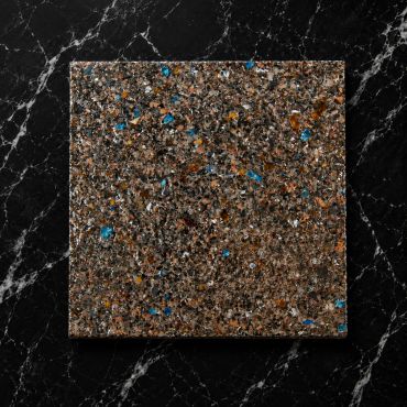 Close-up of a textured, multicolored surface on a black marble background.