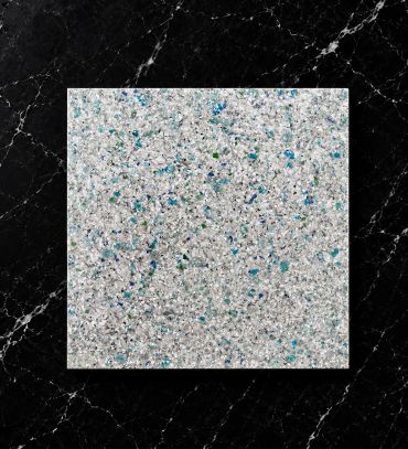 Close-up of a textured surface with blue, green, and white speckles on a black marble background.