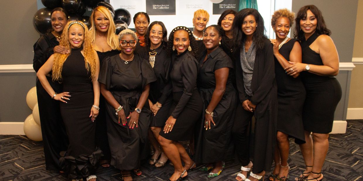 Group of women dressed elegantly in black posing together at an event.