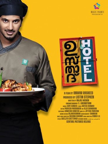 Chef holding a plate of grilled food with hotel sign in Malayalam and English.