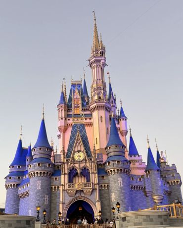 Magical castle with blue turrets at sunset.