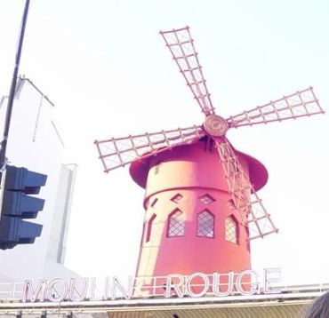Iconic red windmill of Moulin Rouge in Paris.