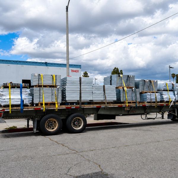 Flatbed trailer loaded with metal stacks.