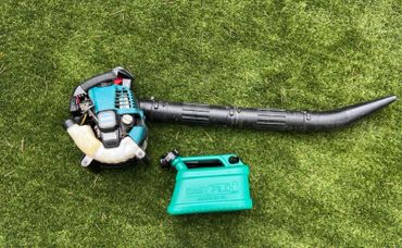 Easyfill no-spill jerry can next to a leaf blower, ready for safe, mess-free refuelling