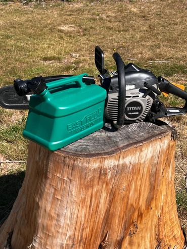 Easyfill no-spill jerry can next to a chainsaw on a tree stump, showing safe refuelling for forestry