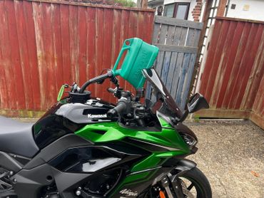 Easyfill no-spill jerry can fuelling a motorbike, ensuring clean and safe refuelling