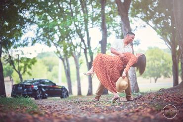 Couple dancing joyfully outdoors surrounded by trees and nature.
