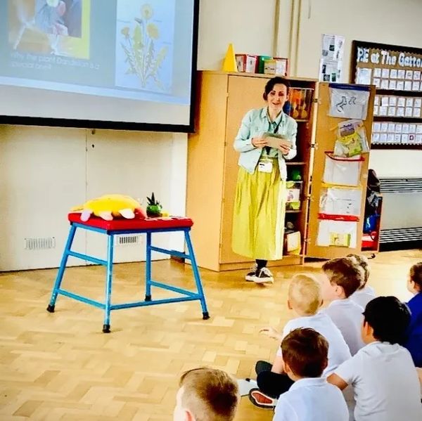 Teacher engaging young students in a classroom presentation about plants.