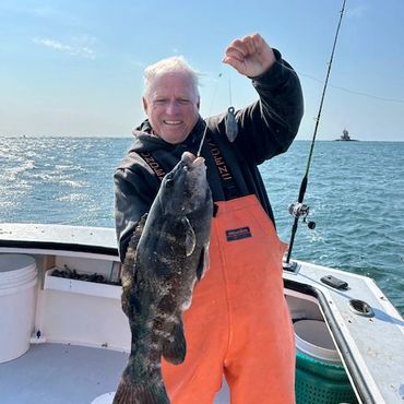 Man holding a large fish on a boat.