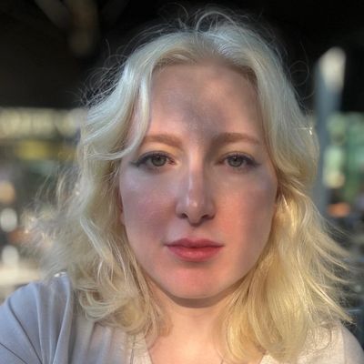 Blonde woman with soft sunlight and shadows on her face.