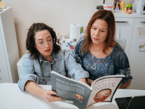 2 Myofunctional Therapist reading a book about Myo