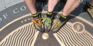 Cyclist feet touching the medallion marking the northern terminus of the Great Allegheny Passage at Point State Park in Pittsburgh 