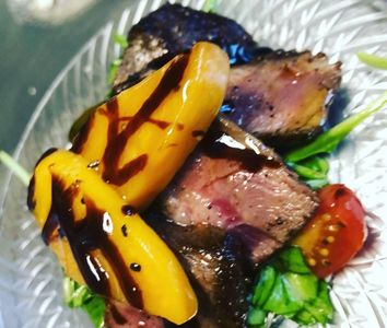 Grilled peach on mixed greens w coffee rubbed pork tenderloin