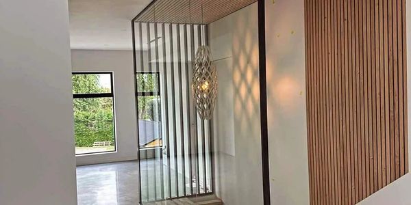 Modern interior with glass wall and wooden ceiling design.