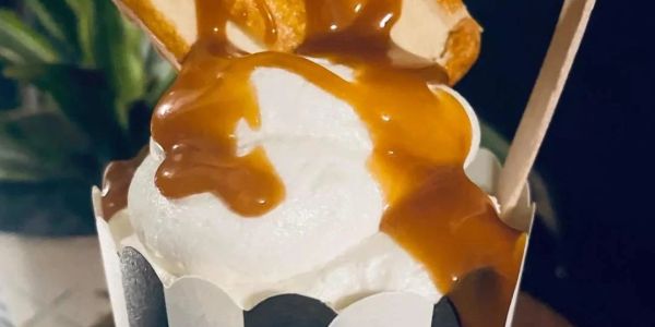 Dessert with caramel sauce and waffle pieces.