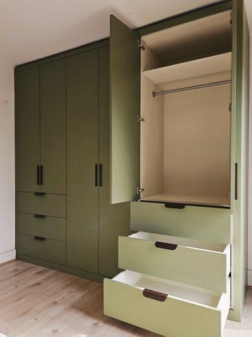 Built in custom wardrobes in sage green with brass handles