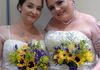 Lesbian brides pose at hotel for Rev Pam's Just married photo.  Budget-wedding-flowers, cheap-brides-bouquets