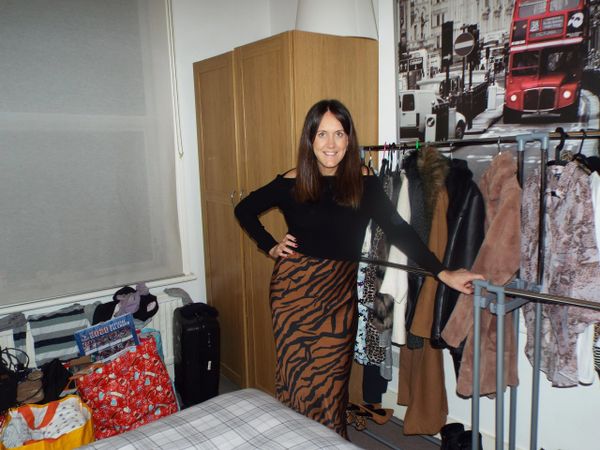 A sister standing in a bedroom having organised and decluttered a bedroom and wardrobes