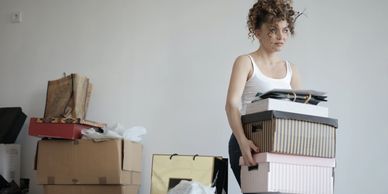 A lady carrying boxes in a room following a house move