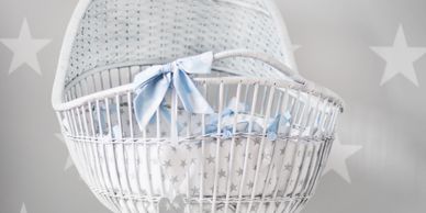 A white mosses basket with blue ribbon