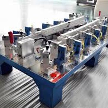 Industrial metalworking machine setup on a blue frame in a workshop.
