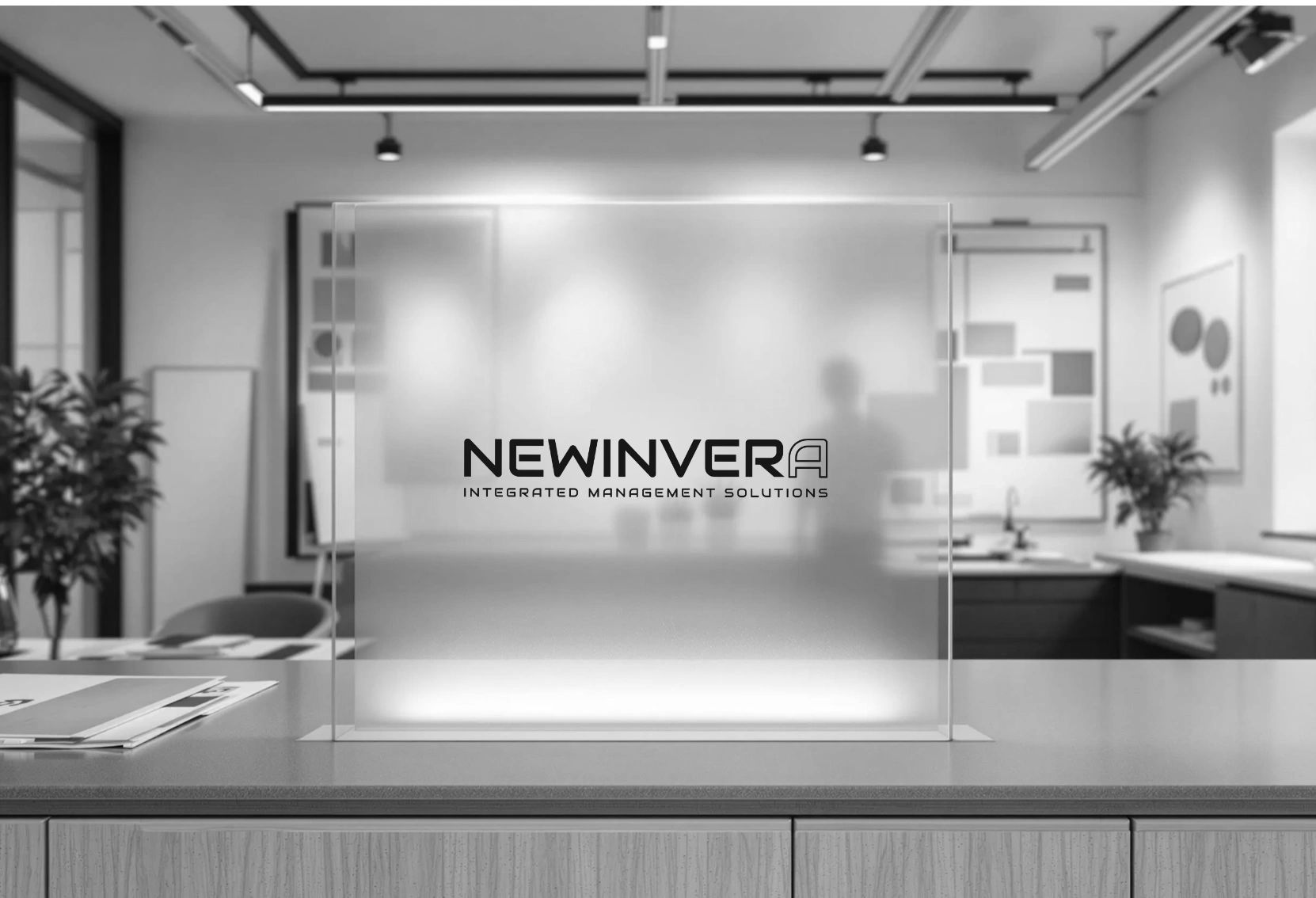 Modern office reception with a frosted glass panel displaying 'NEWINVERA Integrated Management Solutions'.