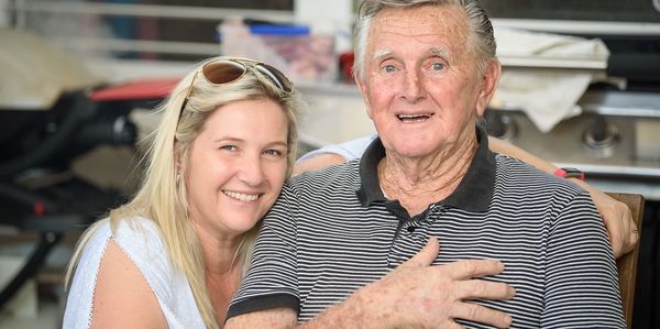 Smiling woman and elderly man posing together.