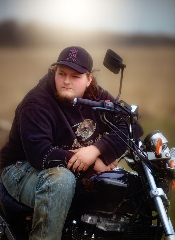 senior boy sitting on motorcycle