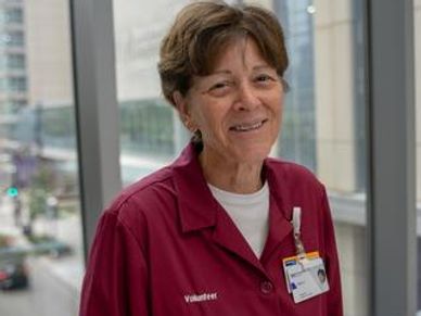 A retired nurse volunteer in a hospital corridor