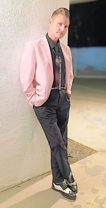Person wearing pink suit jacket.