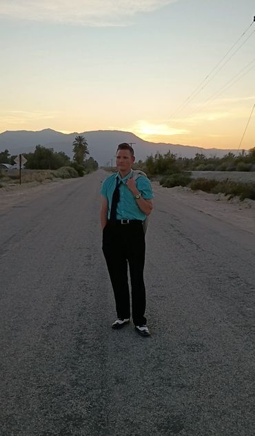 Man standing on desert road.