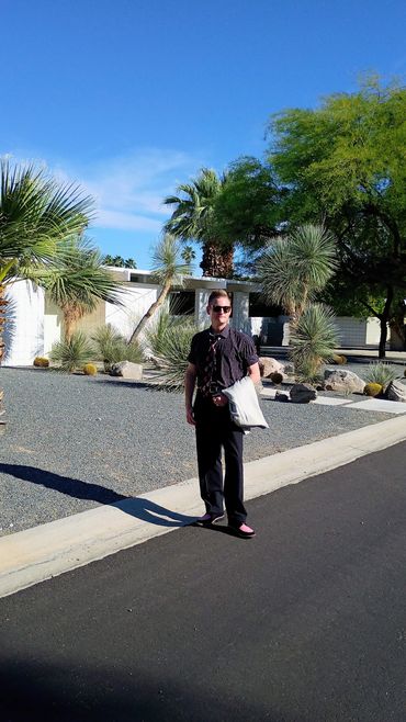 Man standing on sunny driveway.