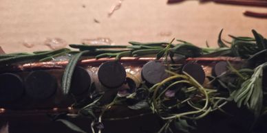 Close-up of a guitar neck with rosemary sprigs laid on top.