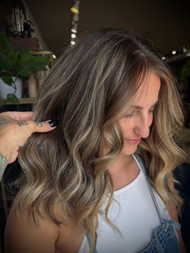 Woman with beautifully styled wavy hair and highlights.