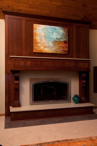 Warm wood-tone fireplace mantle and surround.