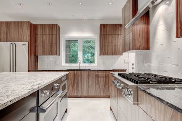 Sleek and modern walnut cabinets, grain matched, along with a painted Island