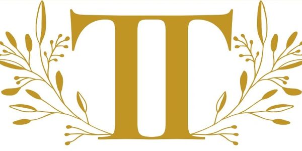 Elegant golden letter 'T' with floral decorations on white background.