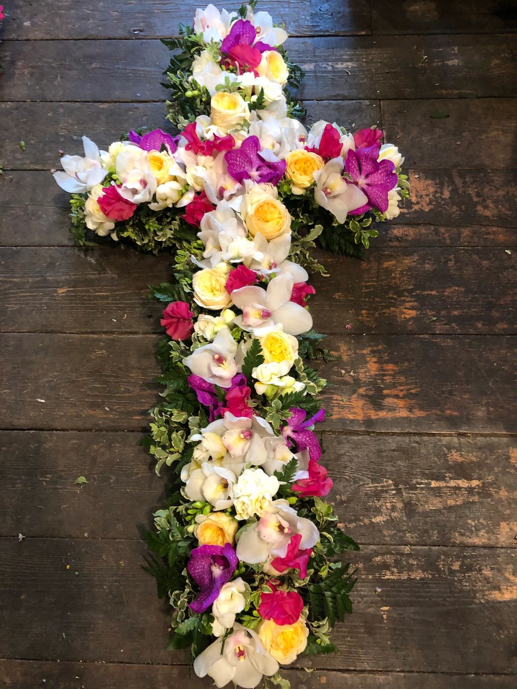 Funeral tribute. Purple and white cross with orchids. London