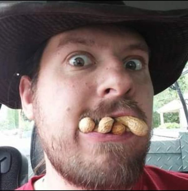 Man with peanuts in his mouth making a funny face.
