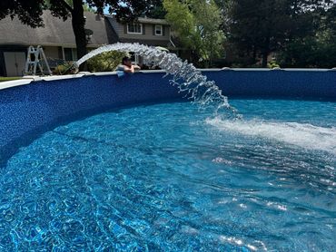 Finished above ground pool liner, getting filled with crystal clear water.