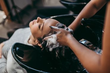 Woman getting her hair washed at a salon basin.