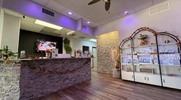 Modern reception area with stone counter, soft lighting, and display shelves.