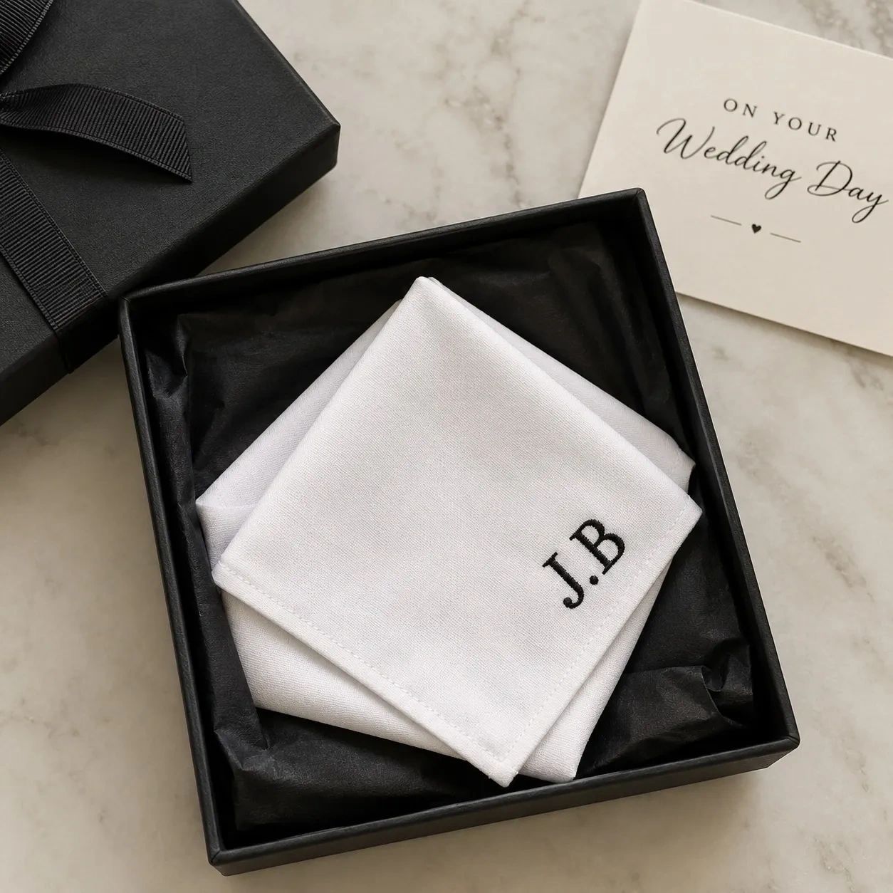 Monogrammed handkerchiefs in a black gift box with a wedding card.