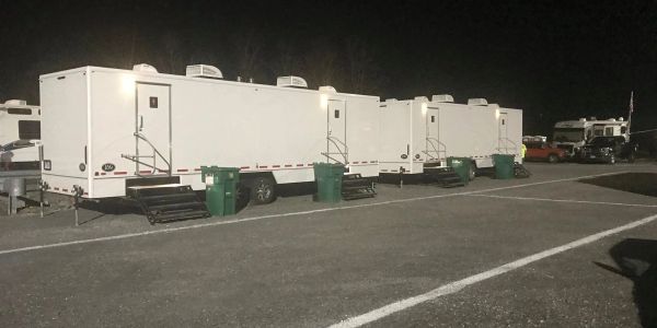 Night view of white trailers with green bins.